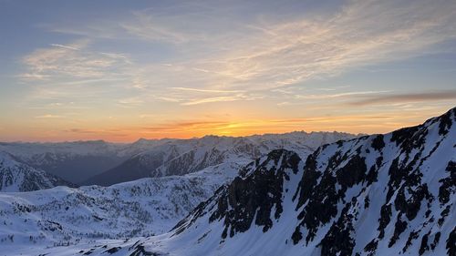 Scenic view of snowcapped mountains against sky during sunset