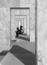 This is a photo of bam land pillars in tehran. this cyclist was sitting between the pillars.