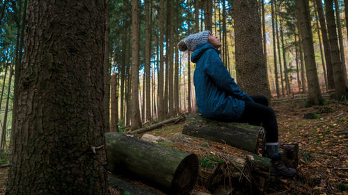 Midsection of man feeding by tree in forest