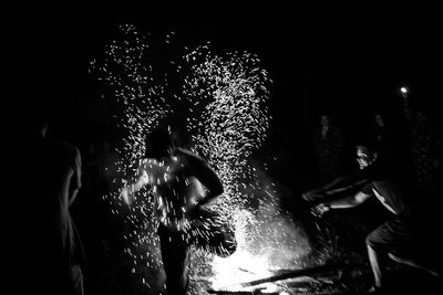 Man and woman in illuminated water at night