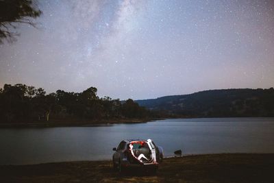 Motor boat in lake against sky at night