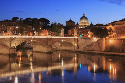 Ponte sant angelo over tiber river in city at dusk