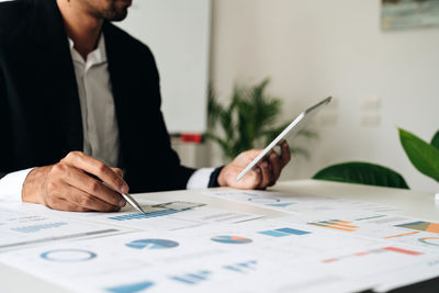 Midsection of businessman working at office