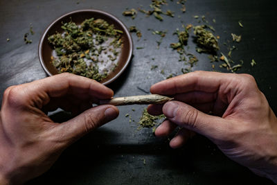 Cropped hands of man holding marijuana joint