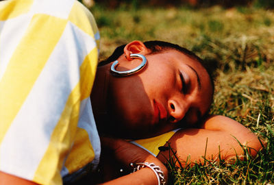 Close-up of young woman sleeping on grassy field at park