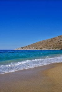 Scenic view of beach against clear blue sky