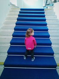 Rear view of girl standing on staircase