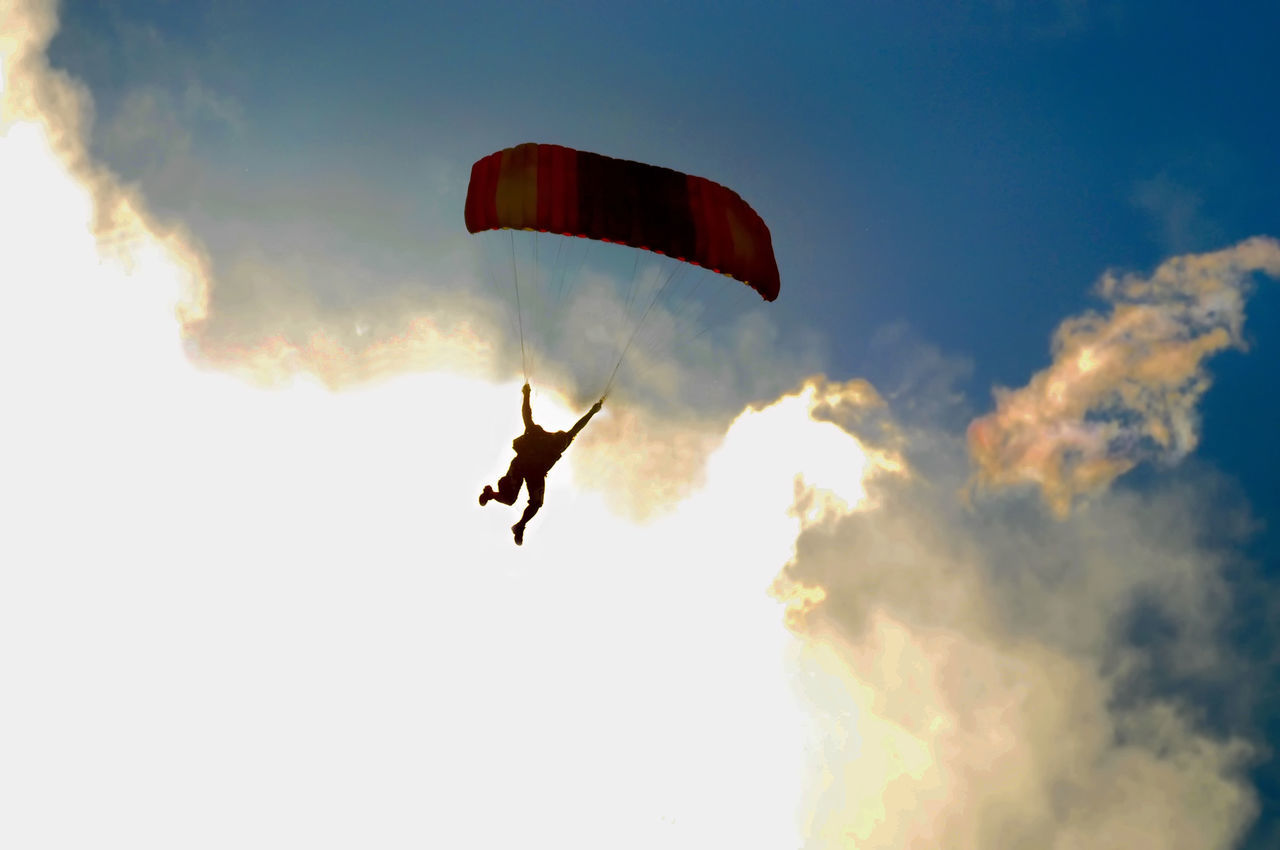flying, mid-air, extreme sports, adventure, sports, sky, joy, paragliding, parachute, exhilaration, leisure activity, nature, motion, parachuting, air sports, cloud, warning sign, risk, one person, silhouette, sign, transportation, gliding, windsports, jumping, full length, courage, communication, environment, day, recreation, lifestyles, sports equipment, air vehicle, positive emotion, activity, pilot, outdoors, fun, safety harness, vitality, low angle view, excitement, emotion, protection, skydiving, on the move, skill, speed, vibrant color, sunlight, multi colored, wind, men