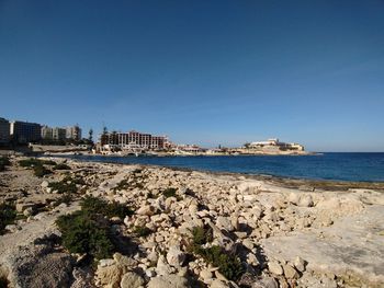 Scenic view of beach against clear blue sky