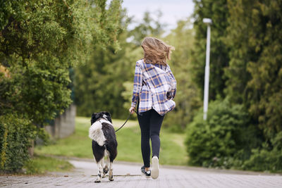 Rear view of woman with dog walking