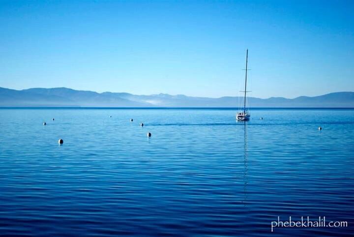water, mountain, clear sky, nautical vessel, transportation, blue, mountain range, boat, copy space, waterfront, sea, tranquil scene, scenics, mode of transport, tranquility, beauty in nature, nature, rippled, lake, sailboat