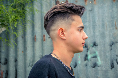 Teenager showing his hairstyle outdoors