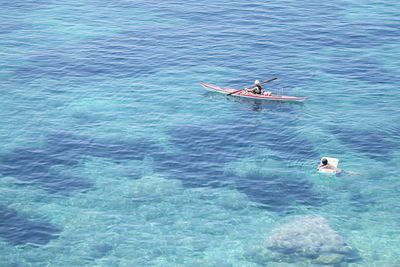 High angle view of people swimming and kayaking at sea