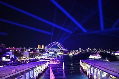 Illuminated bridge over river at night