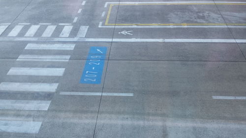 High angle view of arrow sign on road of the airport 