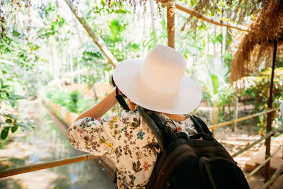 Rear view of woman wearing hat standing outdoors