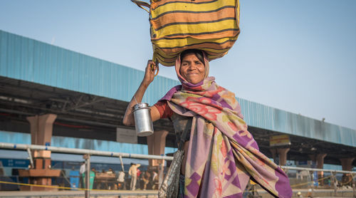 Low angle portrait of smiling woman against sky