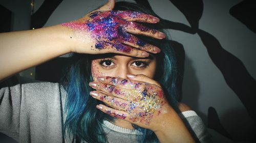 Close-up of young woman with glitter on hand