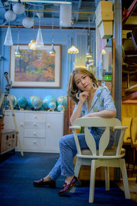 Young woman sitting on chair at table