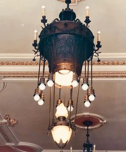 Low angle view of illuminated chandelier hanging on ceiling