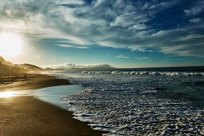 Scenic view of beach against sky during sunrise