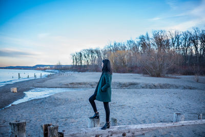 Side view of woman standing on snow covered landscape