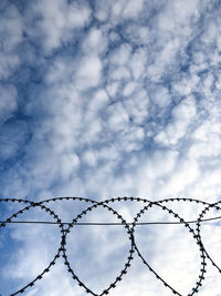 Low angle view of barbed wire against sky