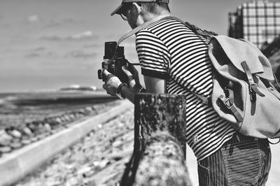 Rear view of woman standing against sea