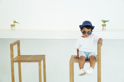 Portrait of cute boy sitting on chair