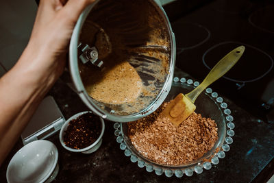 High angle view of hand holding coffee on table