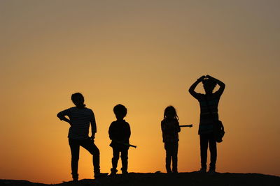 Silhouette of couple standing at sunset