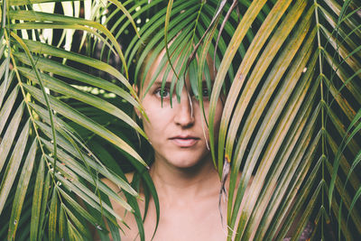 Portrait of woman amidst palm leaves