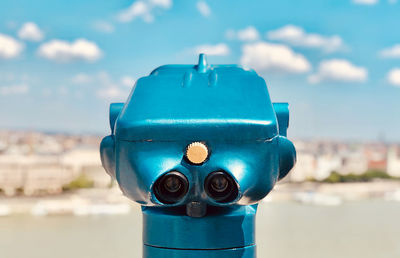 Close-up of coin-operated binoculars against sky