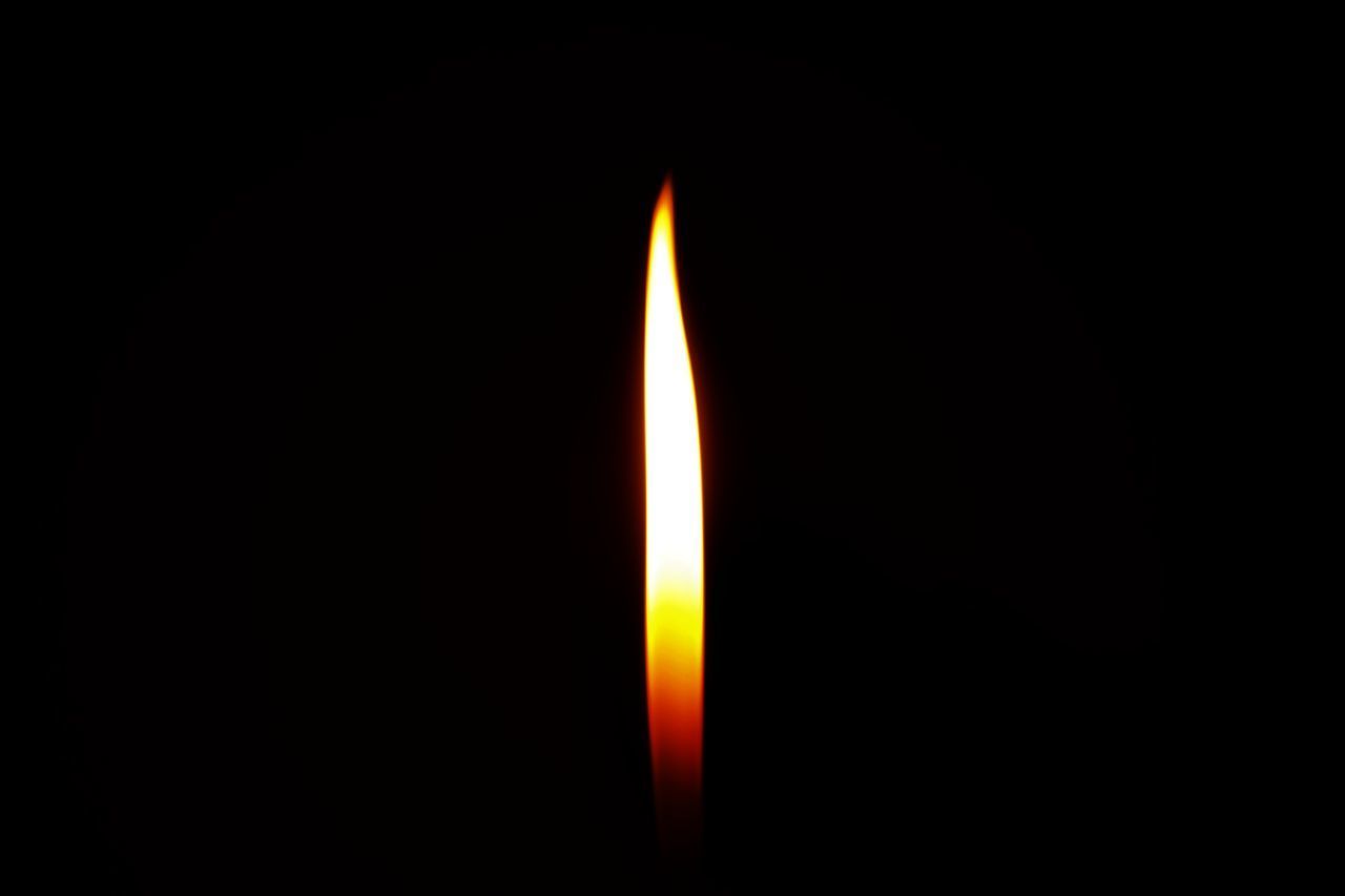 CLOSE-UP OF BURNING CANDLE