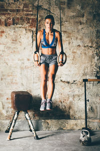 Portrait of young woman exercising in gym