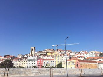 Buildings in city against clear blue sky