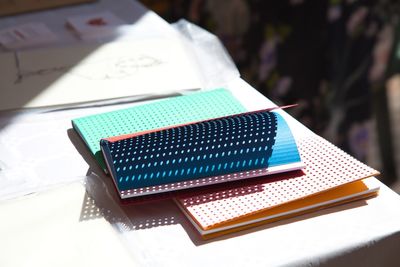 High angle view of multi colored book on table during sunny day