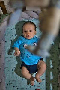 Portrait of cute baby lying down on bed