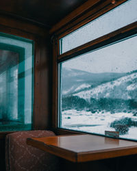 Snowcapped mountain seen through train window