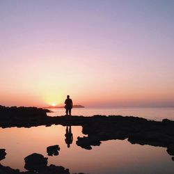 Silhouette of people standing in water