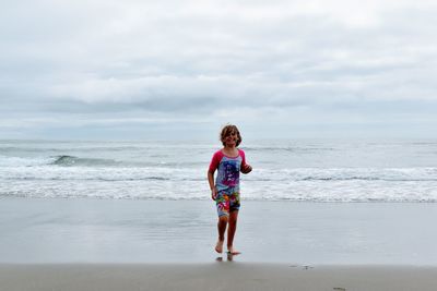 Childn running on beach against sky