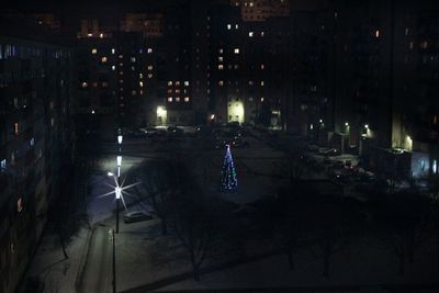 Crowd at illuminated city against sky at night