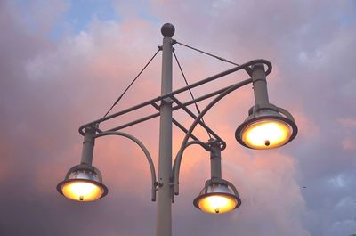 Low angle view of illuminated street light against sky