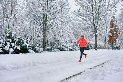 Running woman, girl runner on snow in park winter day. run, sport concept, leisure and freedom.