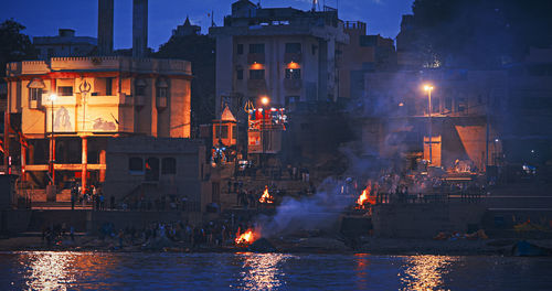 Illuminated buildings in city at waterfront
