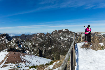 Adult couple taking selfie at pico do areeiro mountain covered with snow in madeira island.