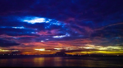 Scenic view of sea against dramatic sky during sunset
