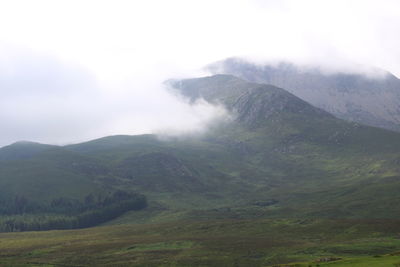 Scenic view of mountain range in foggy weather