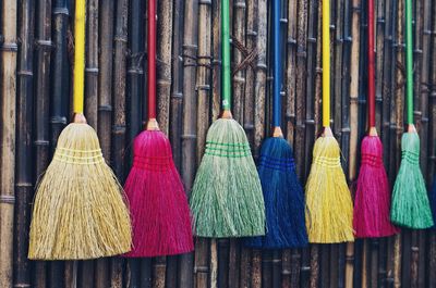 Colorful brooms hanging for sale at market