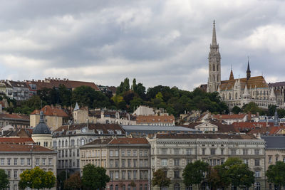 View of buildings in city against cloudy sky